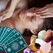 Client receiving healing reiki with wisdom cards and gemstones in foreground